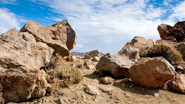 Big rocks and boulders in the rocky desert against blue sky.