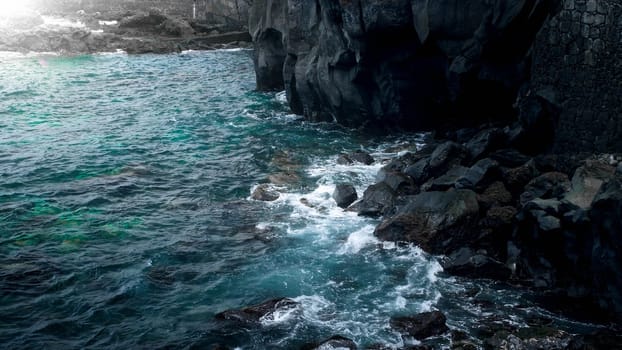 High black volcanic cliffs and rockes on the ocean coast.