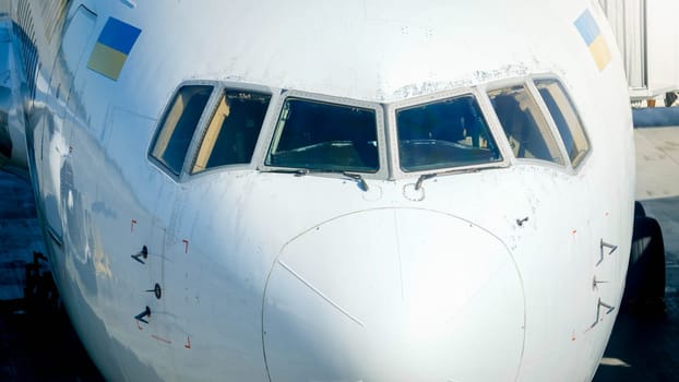 Nose of the airplane with pilot cockpit and wide windshield.