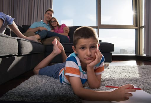Happy Young Family Playing Together at home on the floor using a tablet and a children's drawing set