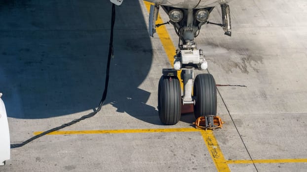 Airplane front chassis parked in airport during airplane checking and maintenance.