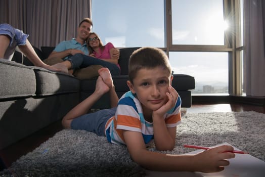 Happy Young Family Playing Together at home on the floor using a tablet and a children's drawing set