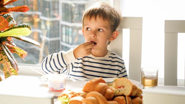 Portrait of little boy in dining room duringbreakfast at sunny morning.