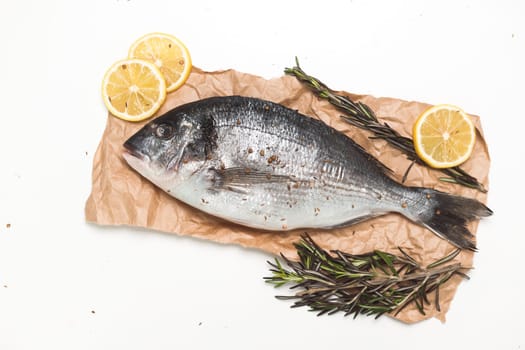 Raw dorada fish or gilt-head bream over white background, flat lay, top view.