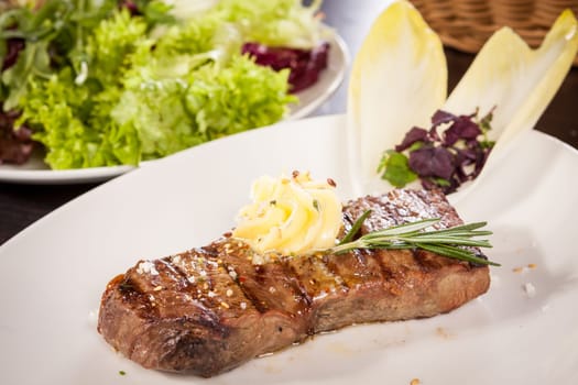 Succulent grilled beef fillet steak with homemade herb butter on a plate