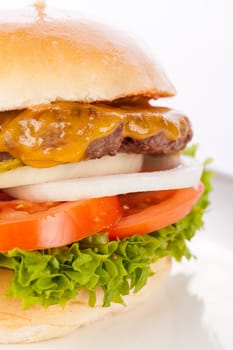 Delicious hamburger cheeseburger with bacon egg and salad on a plate isolated on a white background