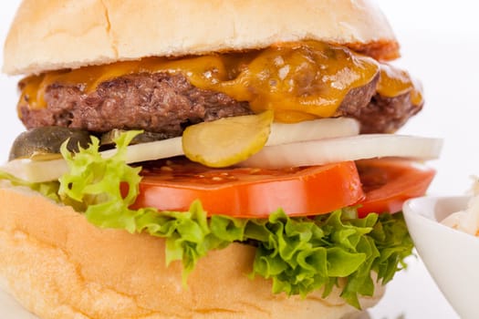 Delicious hamburger cheeseburger with bacon egg and salad on a plate isolated on a white background