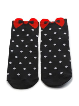 Pair of black socks with white polka dots with a red bow. Isolate.