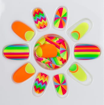 Plastic colored fake nails on a white palette.