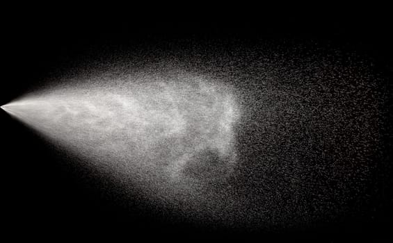 Spraying of water in motion on black background.