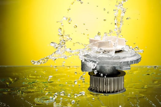 Auto parts, engine cooling pump in water splash on yellow gradient background.