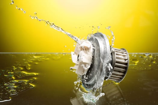 Auto parts, engine cooling pump in water splash on yellow gradient background