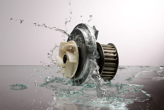 Auto parts, engine cooling pump in spurts of water on a light gradient background