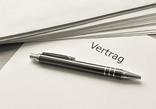 Contract and ballpoint pen are on a table