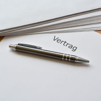 Contract and ballpoint pen are on a desk