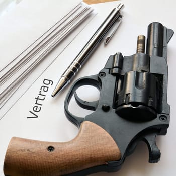 dubious contract and a revolver lie on a table