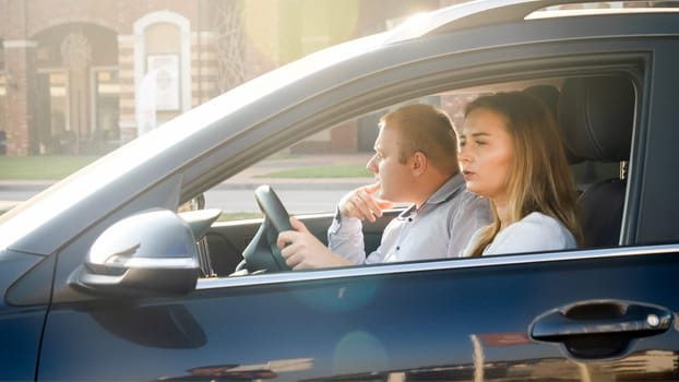 Portrait of beautiful female driver with her husband driving a car.