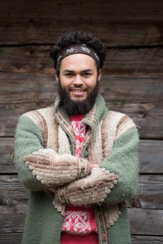 portrait of young hipster,  man with beard in front of old vintage wooden house
