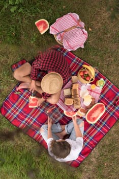 Couple in love enjoying picnic time drink and food in beautiful nature on the river bank top view