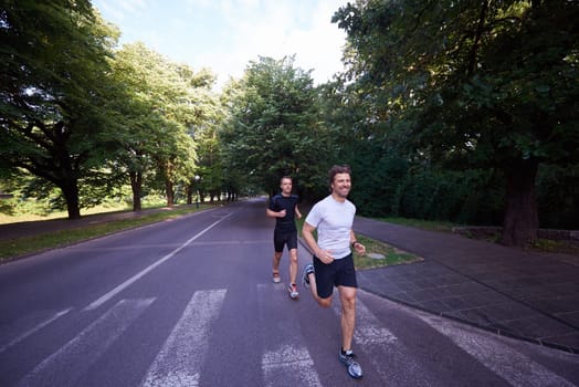 healthy athlete man jogging at morning on empty  roat in the city
