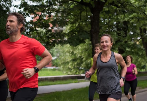 group of healthy people jogging in city park, runners team on morning training