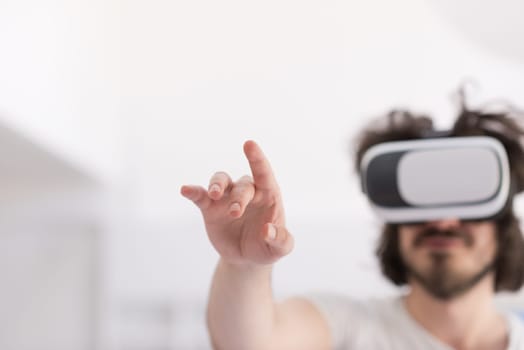 happy man getting experience using VR-headset glasses of virtual reality at home