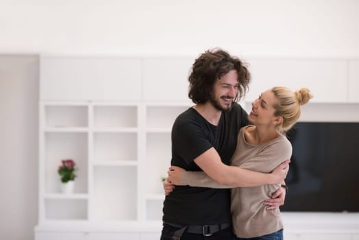 Portrait of a happy young beautiful couple hugging in their new home