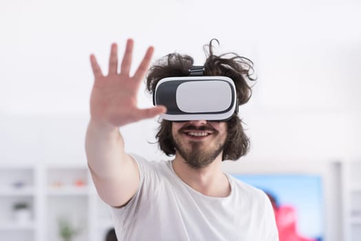 happy man getting experience using VR-headset glasses of virtual reality at home