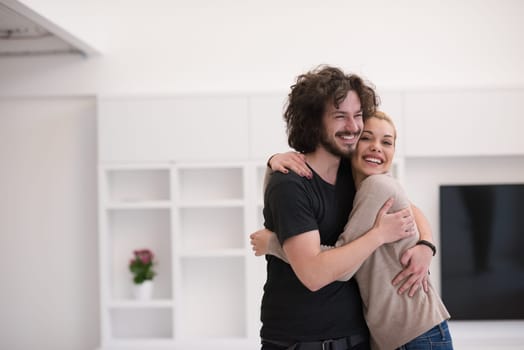 Portrait of a happy young beautiful couple hugging in their new home