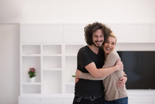 Portrait of a happy young beautiful couple hugging in their new home