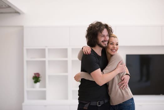 Portrait of a happy young beautiful couple hugging in their new home