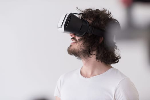 Happy man getting experience using VR headset glasses of virtual reality, isolated on white background