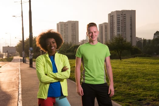 portrait of a young African American beautiful woman and a young man jogging in the city