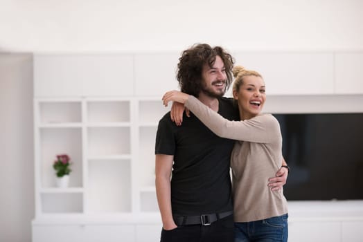 Portrait of a happy young beautiful couple hugging in their new home