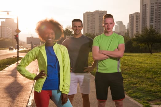 Portrait of multi-ethnic group of young people on the jogging beautiful summer evening as the sun sets over the city