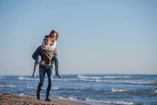 Men Giving Piggy Back Rides to his girlfriend At Sunset By The Sea, autumn time
