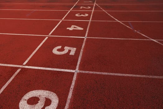 Red athletic track treadmill at the stadium with the numbering.