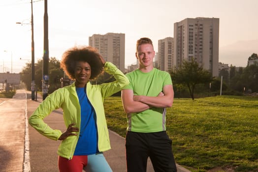 portrait of a young African American beautiful woman and a young man jogging in the city