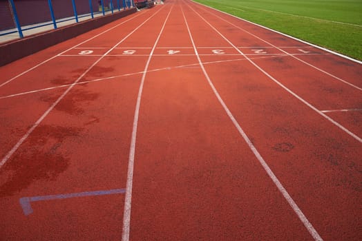 Red athletic track treadmill at the stadium with the numbering.