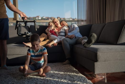 happy couple spending time with kids using tablet computer on sofa at home