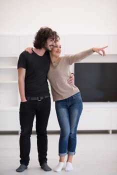 Portrait of a happy young beautiful couple hugging in their new home