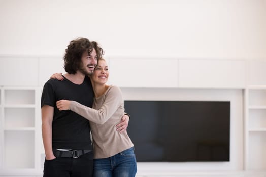 Portrait of a happy young beautiful couple hugging in their new home