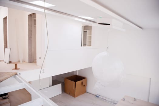 Interior of empty stylish modern open space two level apartment with white walls and large round chandelier in the middle ready to move in