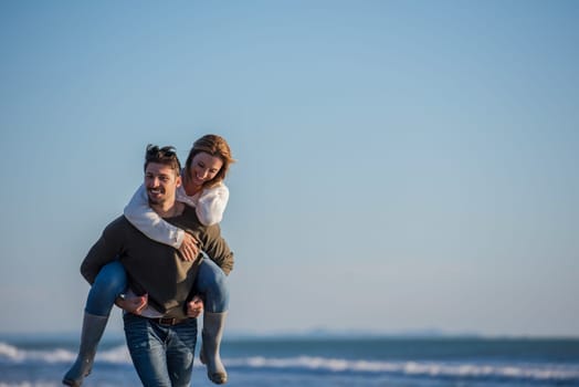 Men Giving Piggy Back Rides to his girlfriend At Sunset By The Sea, autumn time