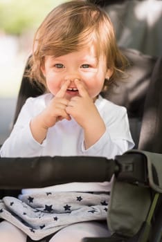little and very beautiful baby girl sitting in the pram and waiting for mom