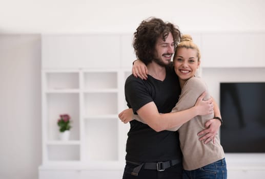 Portrait of a happy young beautiful couple hugging in their new home