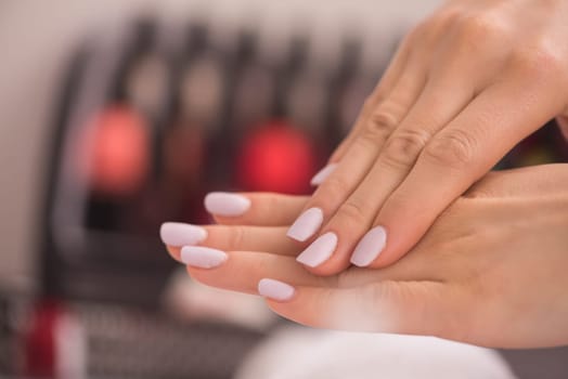 Beautiful fingers with french manicure on the towel. Manicure in a beauty salon.