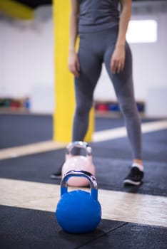 young  woman athlete exercise with fitness kettlebell at cross fitness gym