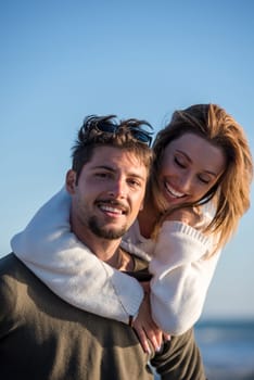 Men Giving Piggy Back Rides to his girlfriend At Sunset By The Sea, autumn time