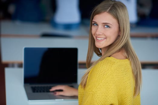 portrait of happy smilling student girl at tech classroom with laptop computer in background